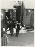 Kungligt besök 1960, med anledning av domkyrkoinvigningen.
Drottning Louise får en hjälpande hand av sin make, kung Gustaf VI Adolf, vid avstigningen från tåget.