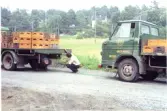 Två lastbilar fyllda med staplade drickabackar från Melins Vattenfabrik år 1972. Fabriken låg på Stomvägen i Kållered. Två män befinner sig vid den främre lastbilen. Till vänster under bilen ses Clas Persson, bakom bilen ses Roger Söderqvist.