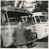 En man i kostym står framför några SJ-bussar, trol. på busstorget/järnvägsplan vid järnvägsstationen, Växjö.
