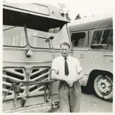 En chaufför i i skjortärmarna poserar framför en stadsbuss, trol. på järnvägsplan/busstorget i Växjö.