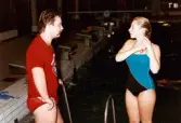 Medlemmar i Lindome Sportdykarklubb övar dykning i Åby simhall i Åby, Mölndal, år 1983. En man och en kvinna samtalar vid bassängkanten.