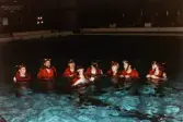 Medlemmar i Lindome Sportdykarklubb övar dykning i Åby simhall i Åby, Mölndal, år 1983. Grupporträtt i bassängen.