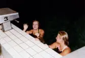 Medlemmar i Lindome Sportdykarklubb övar dykning i Åby simhall i Åby, Mölndal, år 1983. Två kvinnor vid bassängkanten.