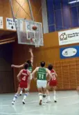 Kvarnby Basket spelar match i Mölndals idrottshus/Aktiviteten, år 1984. Motståndarlag och slutresultat är okända.