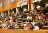 Kvarnby Basket spelar match i Mölndals idrottshus/Aktiviteten, år 1984. Motståndarlag och slutresultat är okända. Publik som följer matchen från läktaren.