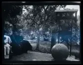 Två kvinnor och barn sitter på en bänk intill minnesmärket 