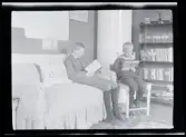 Två pojkar sitter och läser.