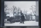 En pojke med skidor står utanför familjen Morthensens villa Solveden, Djursholm.
