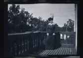 Elin Morthensen (född Anrep) porträtterad i hatt med fjäder, på balkongen till familjen Morthensens villa Solveden, Djursholm.