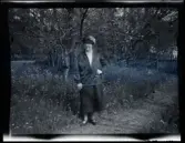 Kvinna (möjligen Elin Mothensen, född Anrep) i trädgården till familjen Morthensens villa Solveden, Djursholm.