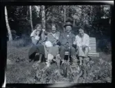 Leonarth Morthensen sitter med tre kvinnor på en parkbänk i en trädgård.