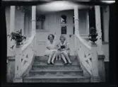Två unga kvinnor, Elsa t.h., med en hund emellan sig, sitter på trappan till  familjen Morthensens villa Solveden, Djursholm.