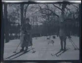En ung kvinna och man på skidor på tomten till familjen Morthensens villa Solveden, Djursholm.