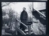 En kvinna porträtterad ståendes i en trappa till  familjen Morthensens villa Solveden, Djursholm.
