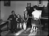 Grupporträtt, fyra personer mot piano. L. E. Norström, Sörstafors, Kolbäck.
Ur Gustaf Åhmans samling.