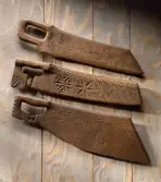 Tre skäkteträn (svingträn) från ovan NM.0025063, NM.0144234 och NM.0071770. Från Östergötland finns skäkteträn med karvsnitts- och knivsuddsornamentik. Materialet är oftast ek.