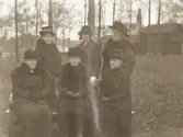 Några äldre kvinnor, och en yngre (lärarinnor vid flickskolan (?), har samlats för fotografen i Strandbjörket, Växjö. I bakgrunden syns kaffestugan, som flyttades dit efter lantbruksutställningen 1916.