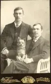 Porträtt av två män och en hund. Text i album: Konrad (osäker vem av dem det är).