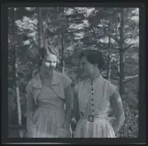 Två unga kvinnor, båda iklädda randiga klänningar.