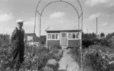 Man framför kolonistuga i Ormesta sommaren 1951