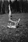 Två skolungdomar gymnastiserar på äng vid Uskavi, 1945