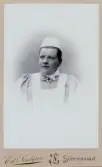 En kvinna i sjuksköterskeuniform med hätta. 
Bröstbild, halvprofil. Ateljéfoto.
Fröken Sally Eksandh, sjuksköterska vid lasarettet i Söderhamn 1894-1905.
