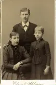 Porträtt av man, kvinna och barn. Text baksida kort: Emmeli, Emil och Mia (otydlig text).