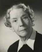 En äldre kvinna i mörk blus med vit krage.
Bröstbild, halvprofil. Ateljéfoto.
Elsa Laudien (f. Eksandh). Vid tiden för fotot bosatt på Kungsholmen, Stockholm.