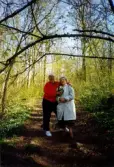 Fotografi taget i maj månad 1998 samband med en skogspromenad.
Inga-Lill Börjesson står till höger i bild och tar emot en bukett med nyplockade vitsippor.