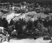 Utsikt mot söder från Östra Berget i Söderhamn. I mitten bebyggelsen utmed Trädgårdsgatan, till vänster upptill ligger sjukhuset och i förgrunden festplatsen på Östra Berget. Foto omkring 1960.