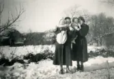 Två kvinnor håller upp varsitt barn. Mamma Inga Maj Berndtsson med sonen Lennart. Solhemsgatan 35 på Solängen i Mölndal en vinterdag 1954.