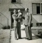 Porträtt av pojken Lennart Berndtsson i famnen på sin morfar Thure Johansson. Farfar Bertil Berndtsson står bredvid. Prytzgatan i Broslätt, Mölndal, cirka 1954.

Thure Johansson (1904-1992) kom från Lilla Edet. Han var till sjöss som ung. Han kom att arbeta vid Partner motorsågar vid Norra Ågatan, där Mölndals dansskola ligger nu. Arbetade även på Papyrus.