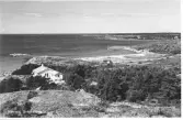 Kärradal. Badstranden. Utsikt från berget med en villa i förgrunden och den steniga kustlinjen. Havsvy.  Badviken Kärra Lilla ses till höger i bild.