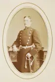 En man i militäruniform med sabel. Han stöder ena armen mot en pelare.
Knäbild, halvprofil. Ateljéfoto.
Kapten Carl Johan Lindström (1849-1917), fr. Kronobergs kungsgård, Växjö.