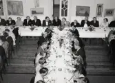 50-årsjubileum den 3 juli 1954 för Kustsanatoriet Apelviken. Middag vid långbord på Societetsrestaurangen. Längs väggen står skärmar med mordern konst. (Se bildnr KSA137-KSA159.)
