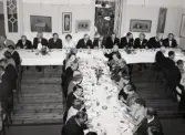 50-årsjubileum den 3 juli 1954 för Kustsanatoriet Apelviken. Middag vid långbord i Societetsrestaurangen. Längs väggen står skärmar med modern konst. (Se bildnr KSA137-KSA159.)
