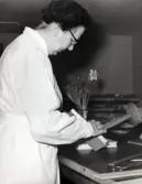 Personalens kurs i bokbinderi vid Kustsanatoriet Apelviken på 1960-talet. Kvinnlig kursdeltagare håller på att färdigställa en bok. Bilderna har tillhört sjukhusintendent Harald Liljenberg (1908-1983). (Se bildnr KSA160-KSA169)