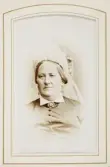 En äldre kvinna i mörk sidenklänning med vit krage och vit hårklädsel. 
Bröstbild, halvprofil. Ateljéfoto.
Fru Aurora von Baumgarten, f. Aschan (1808-1895), Växjö. Gift 1833 med överstelöjtnant Per Reinhold von Baumgarten (1805-1863).