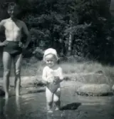 Leif Berndtsson med sonen Lennart Berndtsson står i vattnet vid badplatsen 