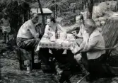 En samling personer sitter i en trädgård och äter vid ett bord. Leif Berndtsson ses som nummer två från höger. Stockholm cirka 1958.