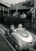 Nöjesfältet Liseberg i Göteborg, år 1959. Pojken Lennart Berndtsson åker åkattraktionen Monte Carlo tillsammans med sin granne Margret Öhrn.