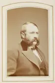 En skäggig man i redingot med sammetskrage, väst och stärkkrage med fluga.
Bröstbild, halvprofil. Ateljéfoto.
Friherre Walfrid Gyllenkrok (1829-1896), Oby, Blädinge.