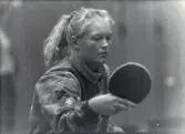 En kvinnlig bordtennisspelare från Mölndals Bordtennisklubb spelar match, år 1992. Idrottshallen är okänd.