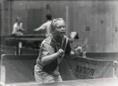 En kvinnlig bordtennisspelare från Mölndals Bordtennisklubb spelar match, år 1992. Idrottshallen är okänd.