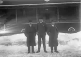 Tre män framför läktare på Eyravallen, 1920-tal