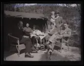 Ett sällskap vuxna och barn fikar utomhus.