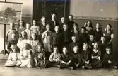 Gruppbild av en skolklass, daterat den 22 maj 1913, då det står på svarta tavlan bakom klassen.