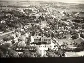 Flygfoto över de södra och västra delarna av Varberg med järnvägen som klyver staden. I förgrunden ses Varmbadhuset som uppfördes 1925 vid Strandgatan. Bebyggelsen till vänster ligger i kv Skepparen och till höger ses Platsarna. Den större byggnaderna på linje bakom badhuset är först lasarettet och sedan Rosenfredsskolan.