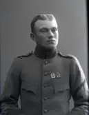 Ateljéfoto av ung man i uniformsjacka med två skyttemärken på bröstet. Beställare: Karl Johansson.
