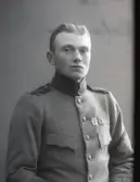 Ateljéfoto av ung man i uniformsjacka med två skyttemärken på bröstet. Beställare: Karl Johansson.